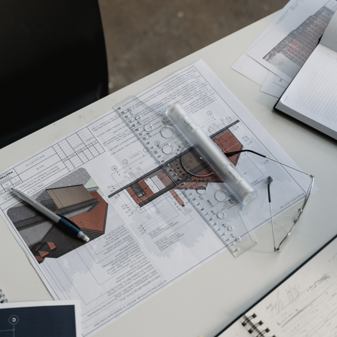 Baupläne mit Zeichnungen, Lineal, Stift und Brille – Architekturplanung Kunstreich Bauunternehmung Wittmund